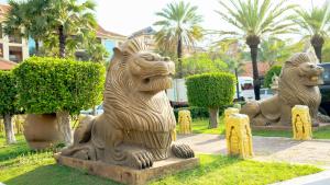 un grupo de estatuas de leones en un parque en Empress Angkor Resort & Spa en Siem Reap