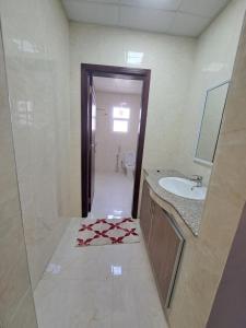 ein Bad mit einem Waschbecken, einem WC und einem Handtuch in der Unterkunft نسائم صلاله NassayemSalalah in Salalah