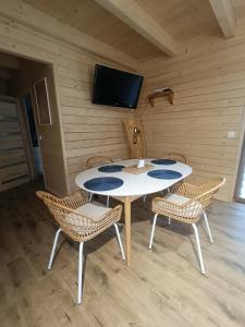 a room with a table and chairs and a tv at Kaszubski dom pod lasem in Studzienice