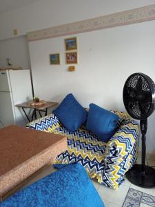 Banana resort في رأس سدر: غرفة معيشة مع أريكة ومروحة