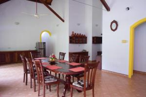 comedor con mesa, sillas y reloj en Nick Villa - Bentota en Bentota