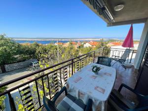 a table and chairs on a balcony with a view at Apartmani Ružić in Jadranovo