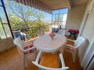 a room with a table and chairs on a balcony at Apartmani Ružić in Jadranovo