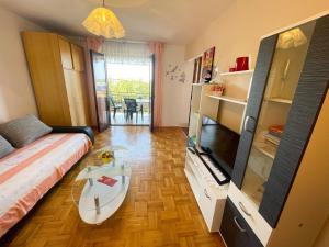a living room with a bed and a glass table at Apartmani Ružić in Jadranovo