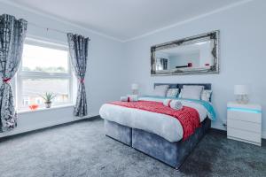 a bedroom with a bed and a mirror at Stunning Spacious 2BR House in East Ardsley 