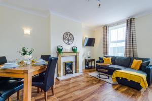 a living room with a table and a couch and a fireplace at Stunning Spacious 2BR House in East Ardsley 