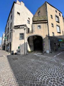 an old building with a tunnel in a street at Charmant studio, au cœur de la ville de Riom in Riom
