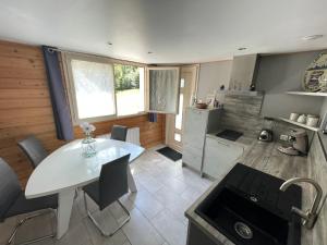 a kitchen with a white table and chairs in a room at Les 3 marguerites in Luzenac