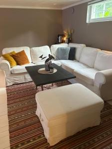 uma sala de estar com um sofá branco e uma mesa em Basement apartment em Sandefjord