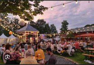 a crowd of people sitting at tables in a park at night at Basement apartment in Sandefjord