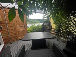 a black table and a chair on a patio at Ferienhaus Zeulenrodaer Meer in Stelzendorf