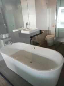 eine weiße Badewanne im Bad mit Waschbecken in der Unterkunft Maya Phuket Airport Hotel - SHA Extra Plus in Nai Yang Beach
