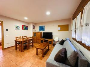 uma sala de estar com um sofá e uma mesa em Apartamento Carlos Bielsa em Bielsa