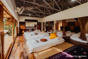 una sala de estar con sofás blancos y almohadas amarillas. en Tirtha Quddus Farmstay en Bentong