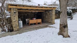 un bâtiment en pierre avec une table dans la neige dans l'établissement Къща за гости Румянцево, à Rumyantsevo