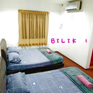 two twin beds in a room with the word bathroom on the wall at Budget House Near Penang Airport Bayan Lepas Penang in Bayan Lepas