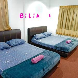 2 camas en una habitación con almohadas azules y rosas en Budget House Near Penang Airport Bayan Lepas Penang, en Bayan Lepas