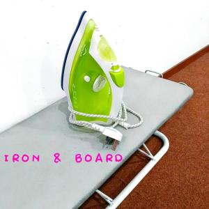 a green iron and board with the words iron and board at Budget House Near Penang Airport Bayan Lepas Penang in Bayan Lepas