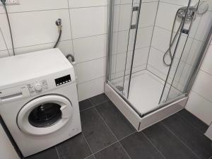 a bathroom with a washing machine and a shower at Heidenheimer Zimmer in Heidenheim an der Brenz