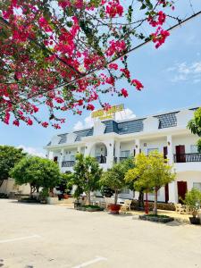 un edificio blanco con flores rosas delante en Ninh Chu 2 Hotel en Phan Rang