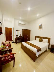 a bedroom with a large bed and a desk at Ninh Chu 2 Hotel in Phan Rang