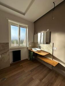 ein Bad mit einem Waschbecken, einem Spiegel und einem Fenster in der Unterkunft Penthouse Ryder Cup in Rom