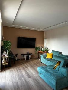 ein Wohnzimmer mit einem blauen Sofa und einem Flachbild-TV in der Unterkunft Penthouse Ryder Cup in Rom