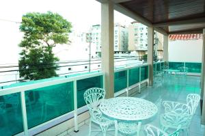 a patio with a table and chairs on a balcony at Pousada Águas do Forte in Cabo Frio