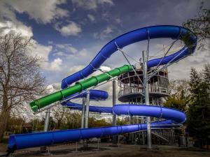 a blue and green water slide in a park at Komfort Home Bursport Bt. ház in Balatonfenyves