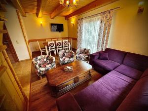 a living room with a purple couch and a table at Domki Istebna 1544 in Istebna