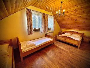 a bedroom with two beds in a wooden cabin at Domki Istebna 1544 in Istebna