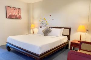 チェンマイにあるRim Tara Residence Patanのベッドルーム(大きな白いベッド1台、椅子付)
