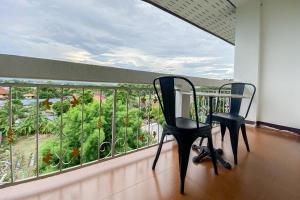 two chairs sitting on a balcony looking out at a garden at Rim Tara Residence Patan in Chiang Mai
