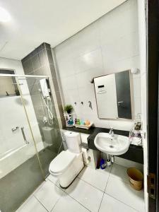 La salle de bains est pourvue de toilettes, d'un lavabo et d'une douche. dans l'établissement Subang Jaya/ Da Men, Cozy Homestay/ Sunway, à Subang Jaya