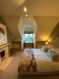 a bedroom with a large bed and a fireplace at Ipsley Lodge Apartment Surrey Hills in Farnham