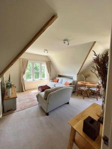 een woonkamer met een bank en een tafel bij Ipsley Lodge Apartment Surrey Hills in Farnham