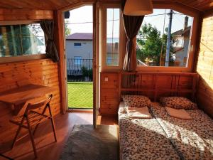 Habitación con cama, escritorio y ventanas. en Liget Apartman Fonyódliget - Balaton lake view 30 m from Beach. en Fonyód