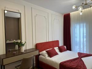 Schlafzimmer mit einem Bett, einem Schreibtisch und einem Spiegel in der Unterkunft Cherry DeLux 103 in Tirana