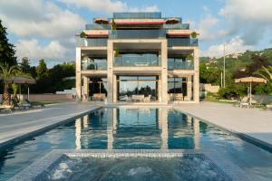 un edificio con piscina frente a un edificio en Villa Elysium Park & SPA en Batumi