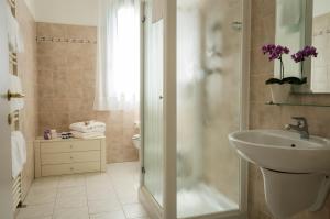 y baño con lavabo y ducha. en Hotel Luna Blu, en Casumaro