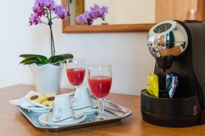 a coffee maker and two glasses of wine on a table at Hotel Luna Blu in Casumaro +9 photos