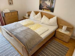 een houten bed met kussens in een slaapkamer bij Sepp, Haus in Finkenberg