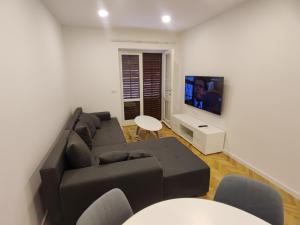 a living room with a couch and a flat screen tv at Apartments Šarić in Makarska