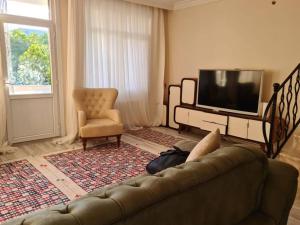 un soggiorno con divano e TV di 4 floors 8 beds villa a Beylikdüzü
