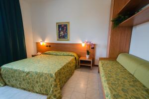 Habitación de hotel con 2 camas y sofá en Hotel Luna Blu, en Casumaro