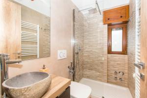 une salle de bain avec un lavabo en pierre et une baignoire dans l'établissement Appartamento sulla piazzetta centrale, à Sauze dʼOulx 53 autres photos