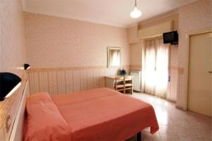 a bedroom with a bed with an orange blanket at Hotel Sud America in Fiuggi