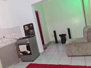 a kitchen with a stove and a couch in a room at ADIA APARTMENTS in Mombasa