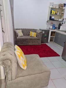 a living room with a couch and a red rug at ADIA APARTMENTS in Mombasa