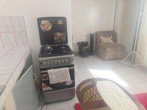 a kitchen with a stove and a chair in it at ADIA APARTMENTS in Mombasa